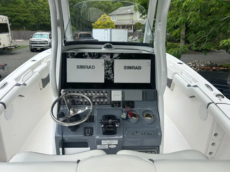Slide: The Image of 2020 Tidewater 272 CC Adventure boat cockpit with dual Simrad displays and steering wheel. - 20