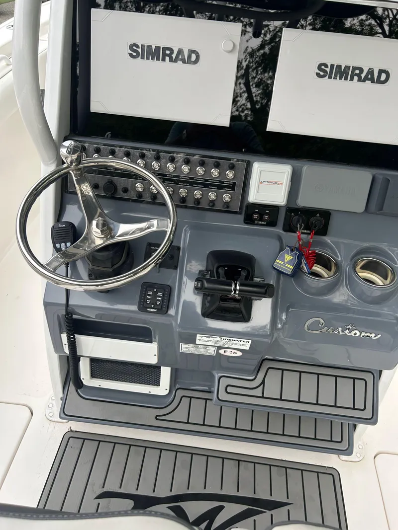 Slide: The Image of 2020 Tidewater 272 CC Adventure boat dashboard with Simrad displays and steering wheel. - 21