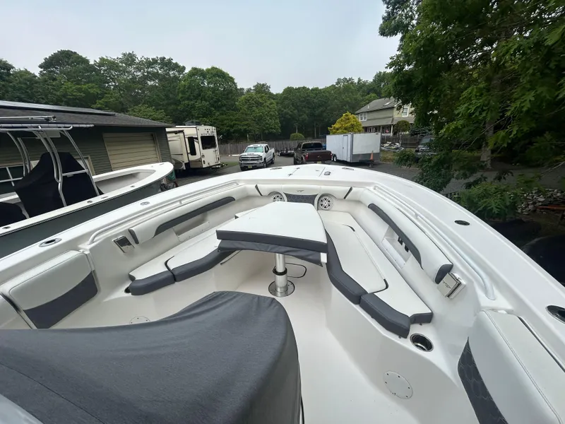 Slide: The Image of 2020 Tidewater 272 CC Adventure boat with spacious seating and table, docked outdoors. - 24
