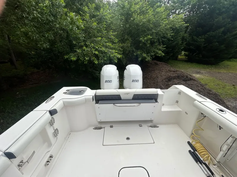 Slide: The Image of 2020 Tidewater 272 CC Adventure boat with dual engines, surrounded by lush greenery. - 27