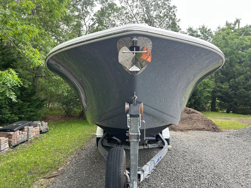 Slide: The Image of 2020 Tidewater 272 CC Adventure boat on trailer, parked outdoors, surrounded by trees. - 30