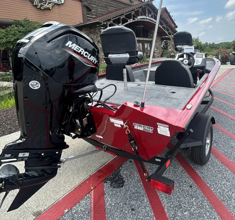 Slide: The Image of 2025 Tracker Pro Team 175 boat with Mercury engine, parked outside a building. - 2
