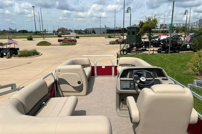 Slide: The Image of 2025 Sun Tracker Party Barge 18 DLX pontoon boat with beige seating and steering console. - 2