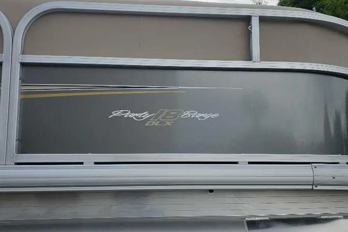 Slide: The Image of 2025 Sun Tracker Party Barge 18 DLX pontoon boat side view with logo. - 2