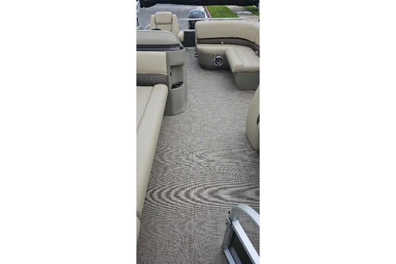 Slide: The Image of 2025 Sun Tracker Party Barge 18 DLX interior with beige seating and carpeted floor. - 3