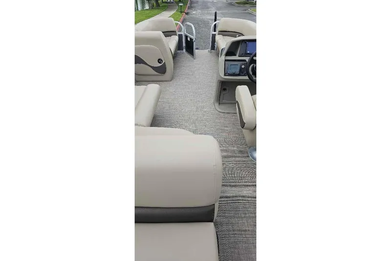 Slide: The Image of 2025 Sun Tracker Party Barge 18 DLX interior with beige seating and modern dashboard. - 4