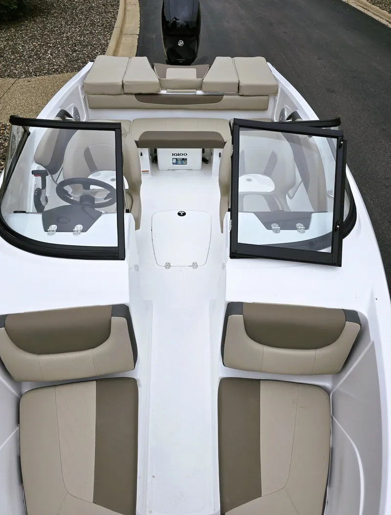 Slide: The Image of 2025 Tahoe 200 S boat interior with open windshield and beige seating. - 2