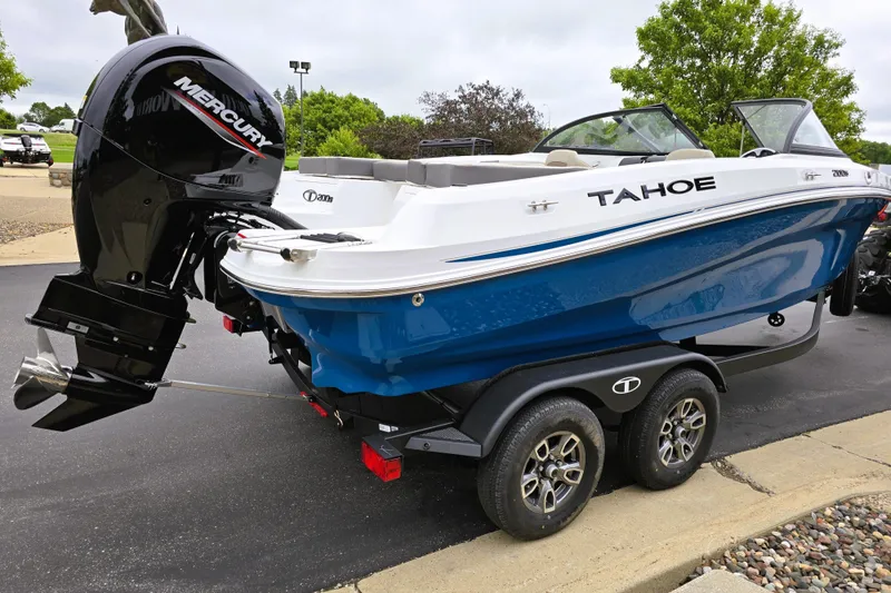 Slide: The Image of 2025 Tahoe 200 S boat with Mercury engine on a trailer, parked outdoors. - 4