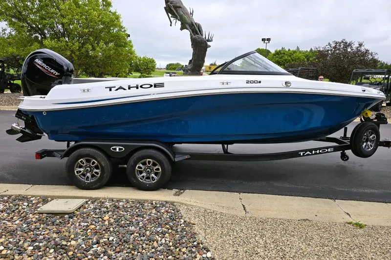 Slide: The Image of 2025 Tahoe 200 S boat on trailer, blue hull, parked outdoors. - 5
