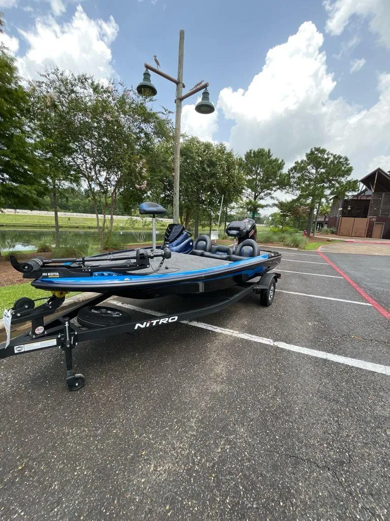 Slide: The Image of 2025 Nitro Z17 boat parked outdoors on a sunny day, surrounded by trees and a building. - 8