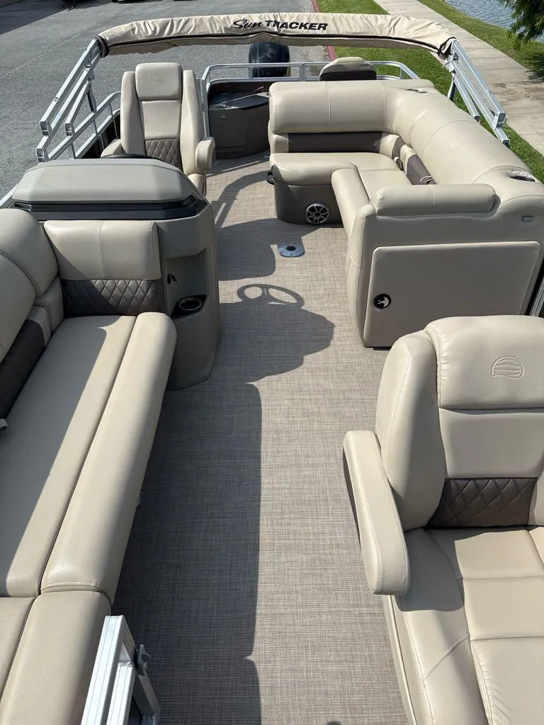 Slide: The Image of 2025 Sun Tracker SportFish 20 DLX pontoon boat with beige seating and spacious interior. - 3