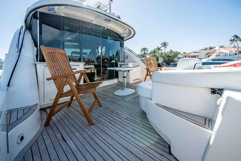 Slide: The Image of Luxurious 2012 Sea Ray 610 Sundancer yacht deck with wooden chairs and sleek design. - 11