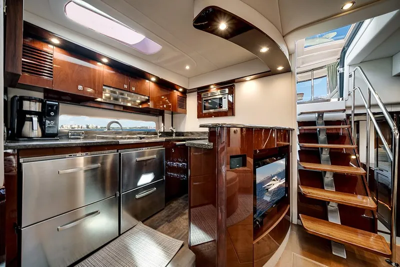 Slide: The Image of Luxurious 2012 Sea Ray 610 Sundancer yacht interior with modern kitchen and elegant wooden staircase. - 28
