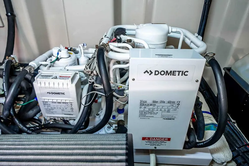 Slide: The Image of Engine room of 2012 Sea Ray 610 Sundancer featuring Dometic equipment and complex piping system. - 48