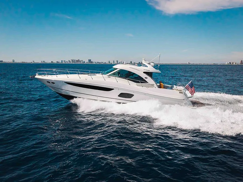 Slide: The Image of 2012 Sea Ray 610 Sundancer yacht cruising on open water under a clear blue sky. - 52