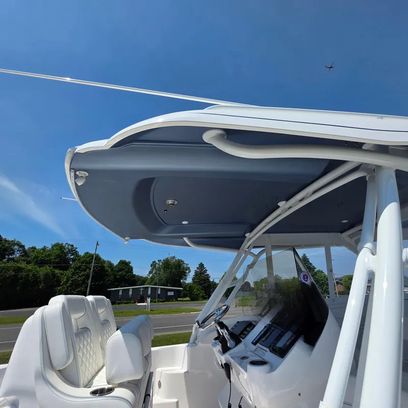 Slide: The Image of 2021 Intrepid 345 Valor boat cockpit with modern seating and controls under a clear blue sky. - 12