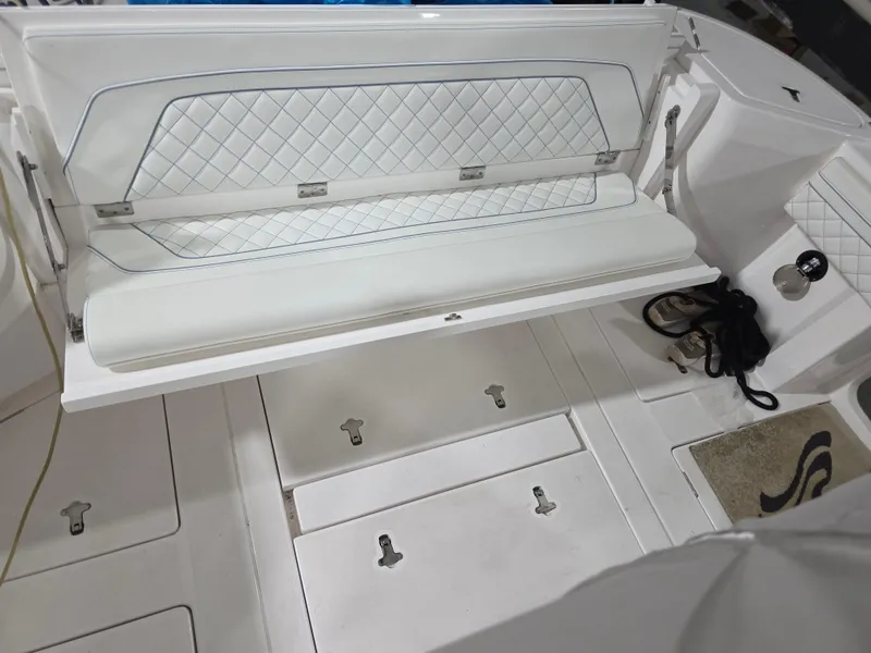 Slide: The Image of 2021 Intrepid 345 Valor boat interior with white cushioned seating and storage compartments. - 16