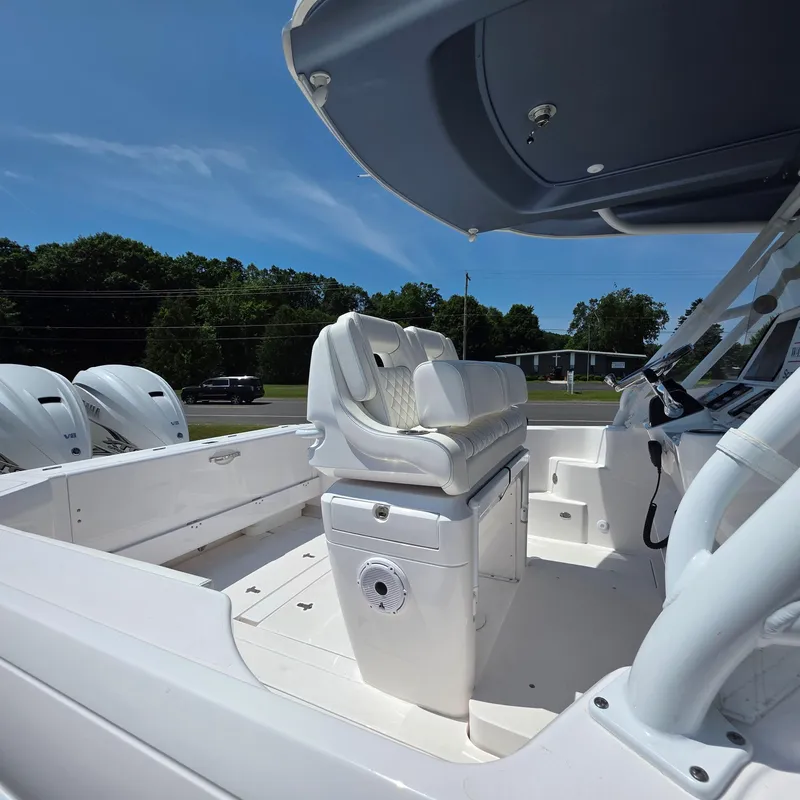 Slide: The Image of 2021 Intrepid 345 Valor boat interior with seating and controls, under clear blue sky. - 18