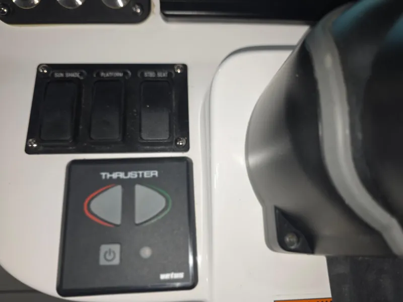 Slide: The Image of Control panel of a 2021 Intrepid 345 Valor boat with thruster buttons. - 23