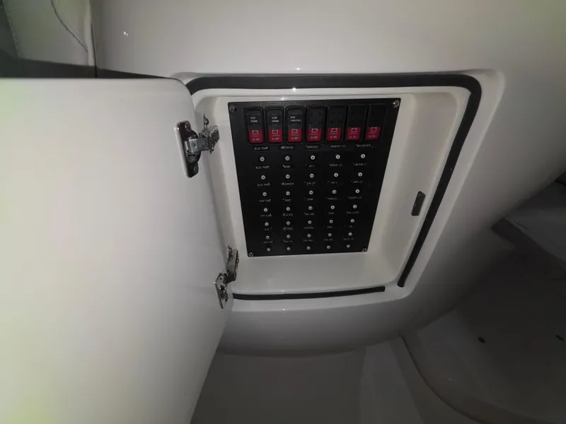 Slide: The Image of Electrical panel inside a 2021 Intrepid 345 Valor boat, featuring multiple switches and circuit breakers. - 28