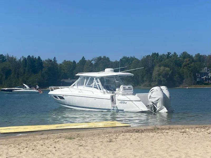 Slide: The Image of 2021 Intrepid 345 Valor boat anchored in calm waters near a beach. - 3