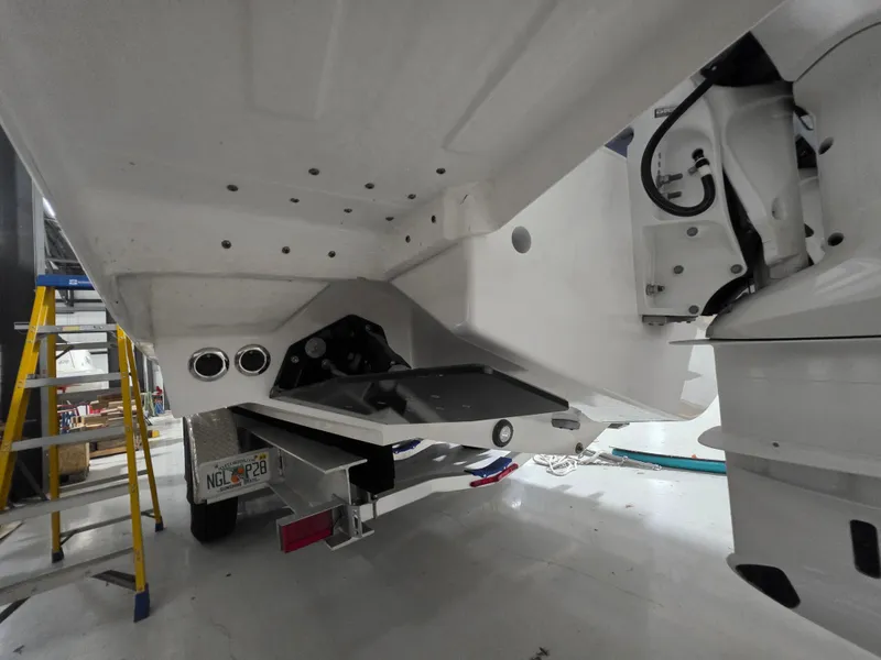 Slide: The Image of 2021 Intrepid 345 Valor boat underside, showcasing hull and mechanical components in a workshop setting. - 30