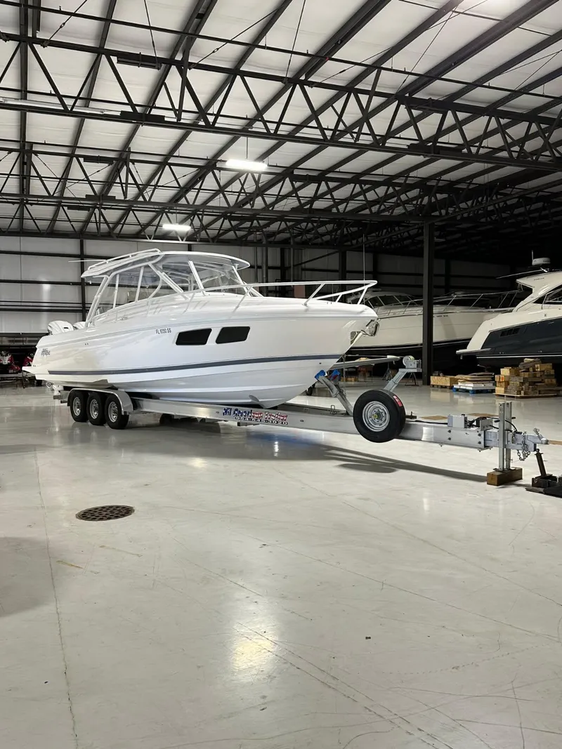 Slide: The Image of 2021 Intrepid 345 Valor boat anchored near sandy beach with trees in background. - 4