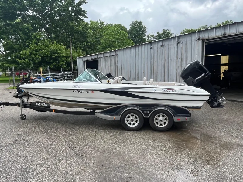 Slide: The Image of 2007 Triton SF-211 boat on trailer, parked outside a metal building. - 4