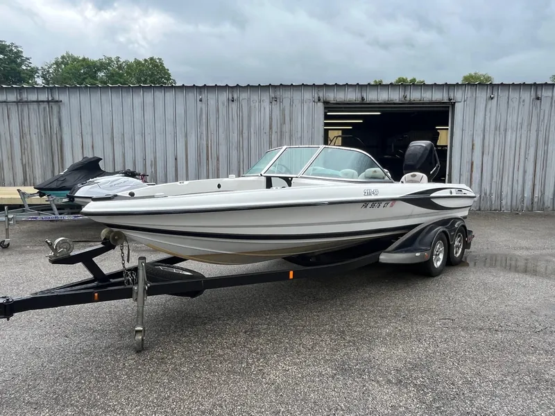 Slide: The Image of 2007 Triton SF-211 boat on trailer, parked outside a metal building. - 5