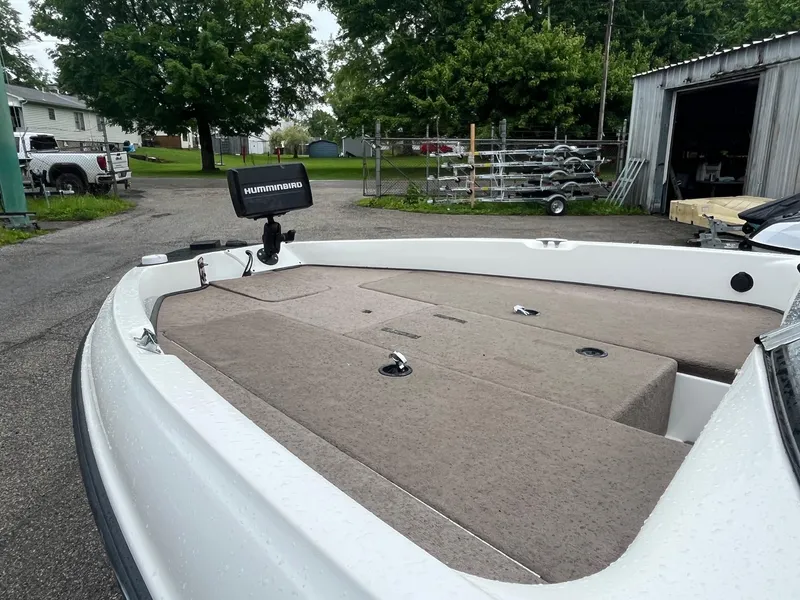 Slide: The Image of 2007 Triton SF-211 boat with Humminbird fish finder, parked near a garage. - 6