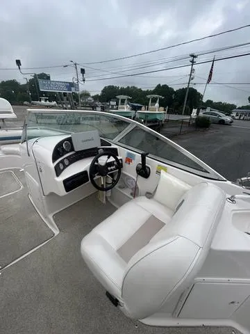 Slide: The Image of 2001 Hurricane 237 Sun Deck boat interior with steering wheel and seating, parked outdoors. - 4