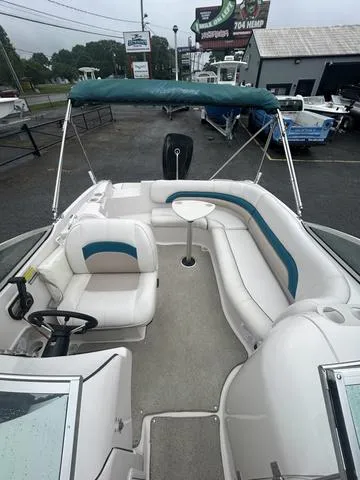 Slide: The Image of 2001 Hurricane 237 Sun Deck boat with seating, table, and canopy in a dealership lot. - 5