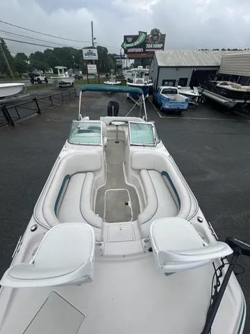 Slide: The Image of 2001 Hurricane 237 Sun Deck boat with spacious seating, docked at a marina. - 6