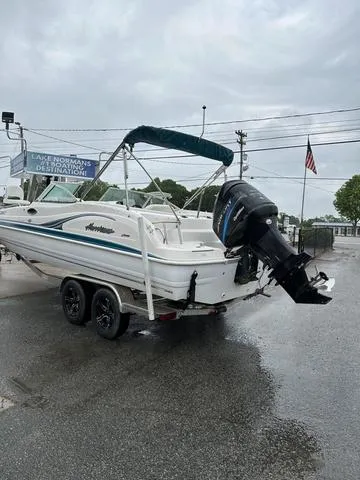 Slide: The Image of 2001 Hurricane 237 Sun Deck boat on trailer, parked outdoors on a rainy day. - 9