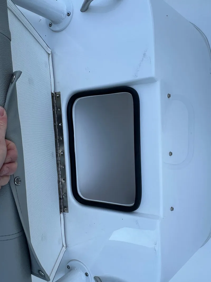 Slide: The Image of 2026 Cape Horn 24XS boat compartment with open hatch and visible hinge. - 12