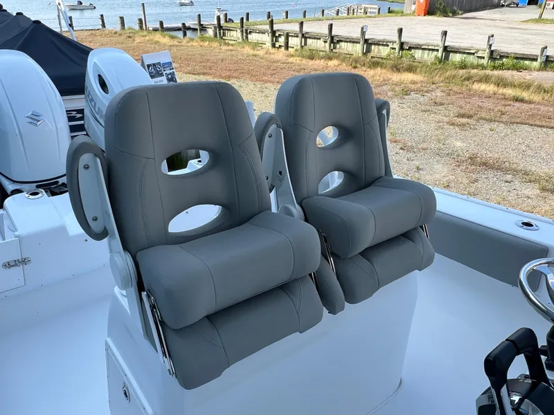 Slide: The Image of 2026 Cape Horn 24XS boat with dual gray cushioned seats, dockside view. - 4