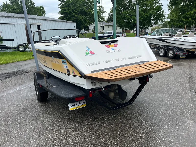 Slide: The Image of 1990 Correct Craft Ski Nautique boat on trailer, rear view, parked outdoors. - 3