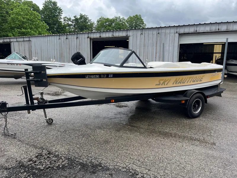 Slide: The Image of 1990 Correct Craft Ski Nautique boat on trailer, parked outdoors near a garage. - 5