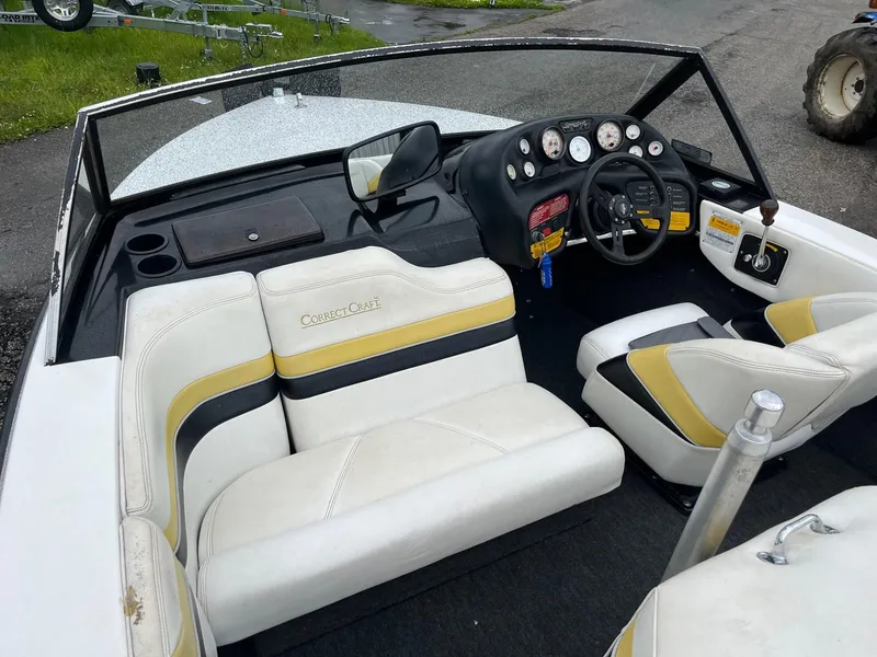 Slide: The Image of 1990 Correct Craft Ski Nautique boat interior with white and yellow seating, dashboard, and steering wheel. - 7