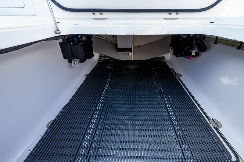 Slide: The Image of 2013 Bahama Quad V10's boat interior with black flooring and storage compartments. - 14