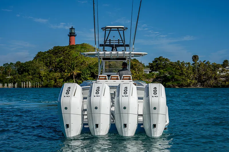 Slide: The Image of Bahama Quad V10's 2013 boat with four engines, cruising near a lighthouse. - 3
