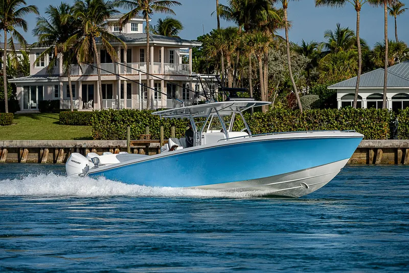 Slide: The Image of 2013 Bahama Quad V10's boat cruising near waterfront homes with palm trees. - 31