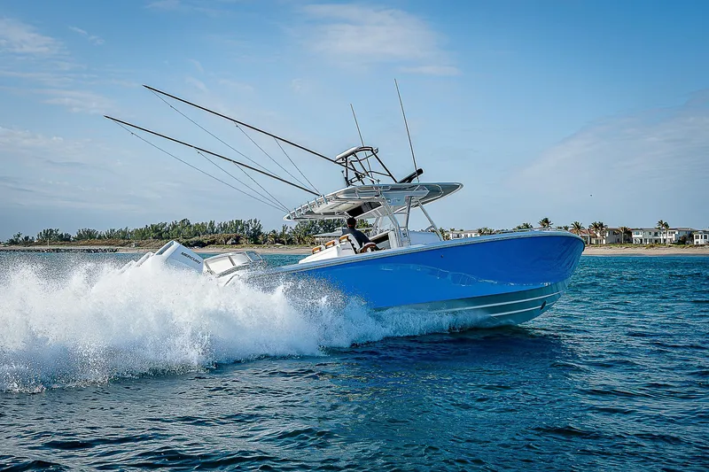Slide: The Image of 2013 Bahama Quad V10's boat speeding on ocean with wake, clear sky background. - 36