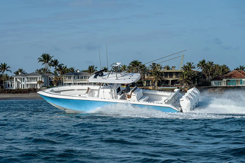 Slide: The Image of 2013 Bahama Quad V10's boat cruising near coastal homes, clear blue water. - 39