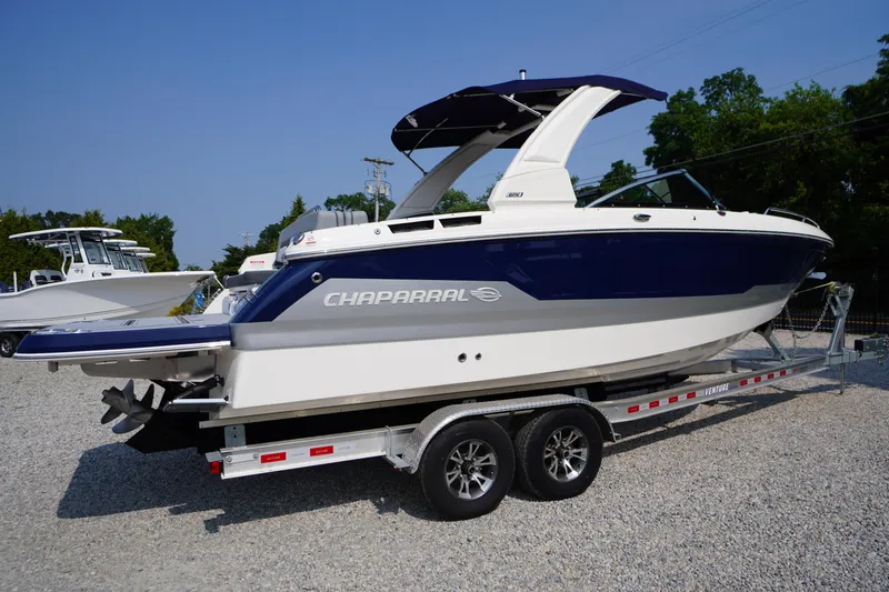 Slide: The Image of 2025 Chaparral 267 SSX boat bow with anchor, displayed outdoors on gravel. - 3