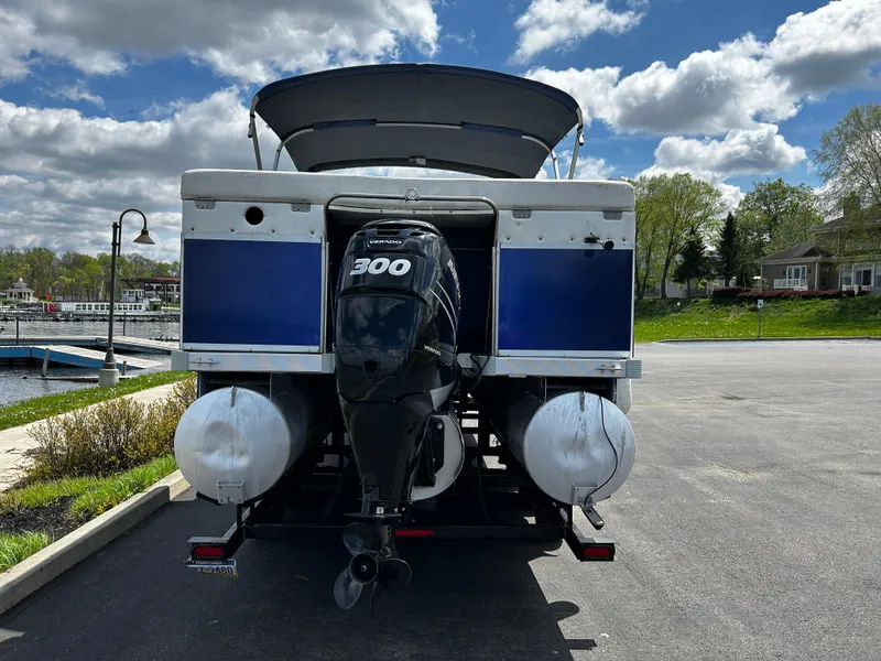 Slide: The Image of 2005 Evolution 26 boat with 300 HP engine, parked near a marina under a cloudy sky. - 13