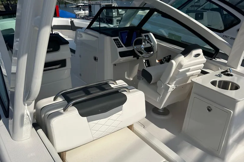 Slide: The Image of 2025 Robalo R257 Dual Console interior with white seating, steering wheel, and sink. - 4