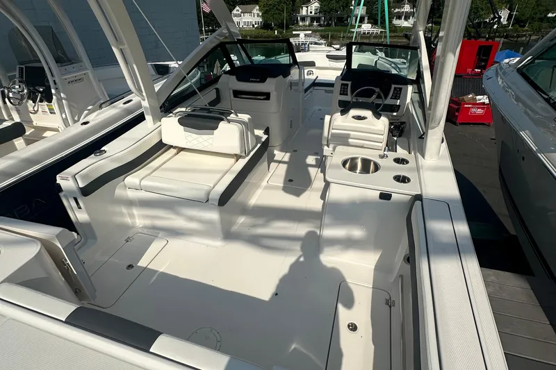 Slide: The Image of 2025 Robalo R257 Dual Console boat interior with seating and helm, docked outdoors. - 8