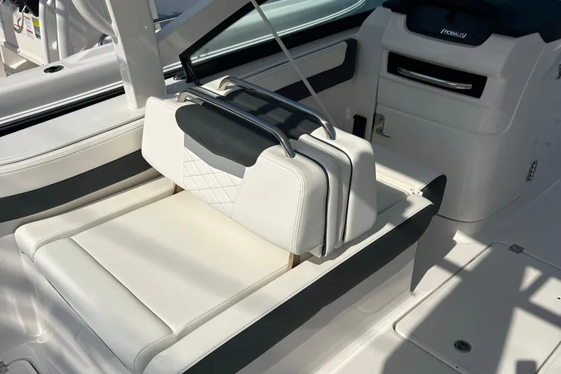 Slide: The Image of 2025 Robalo R257 Dual Console boat interior with white cushioned seating and sleek design. - 9