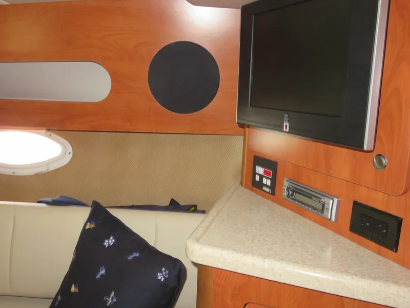 Slide: The Image of Interior of 2008 Rinker 280 Express Cruiser with TV, seating, and wood paneling. - 11